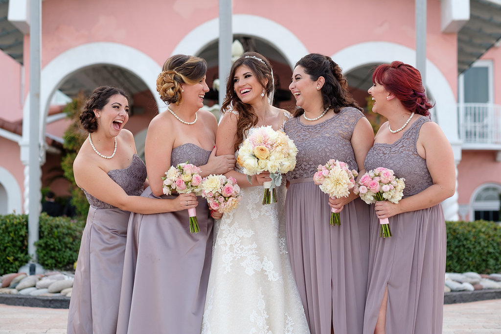 Outdoor Bridal Party Portrait, Bride in Lace Pronovias Dress with Silver Headband, Bridesmaids in Mismatched Mauve Dusty Purple David's Bridal Lace Bodice Dresses, with Blush PInk, Champagne, Ivory Rose Bouquets | Historic Waterfront St Pete Beach Hotel Wedding Venue The Don CeSar | Tampa Bay Wedding Photographer Marc Edwards Photographs
