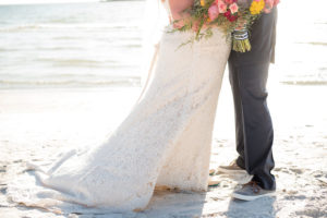Outdoor Beach Wedding Portrait, Bride in Lace Dress with PInk and Orange Tropical Bouquet with Greenery and Striped Ribbon, Groom in Navy Suit with Gray Boat Shoes | St Pete Wedding Photographer Caroline and Evan Photography | Tampa Bay Wedding Dress Shop Truly Forever Bridal