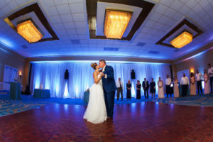 Indoor Hotel Ballroom Wedding Reception First Dance Portrait, Groom in Blue Suit with Blue Linens, Draping, and Uplighting | Waterfront Tampa Bay Hotel Wedding Venue Hilton Clearwater Beach