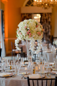 Hotel Ballroom Wedding Reception Round Table with Extra Tall Hydrangea, White ORchid and Pink Rose Centerpiece in Glass Vase, Gold Table Number, Mini Liquor Bottle Favor, Black Chiavari Chairs | Champagne Textured Linen Rentals Kate Ryan Linens | Historic St Pete Beach Hotel Wedding Venue The Don CeSar