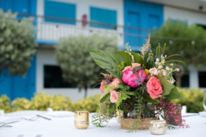 Tropical Pink and Orange Floral Low Centerpiece with Thistle and Ferns and Greenery in small vase wrapped in Twine, and Gold Mercury Votive Candleholders | St Pete Beach Venue The Postcard Inn