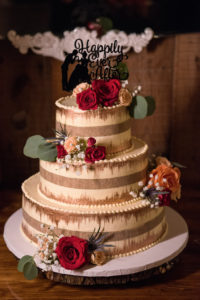 Three Tier Naked Icing with Vertical Stripe Wedding Cake on Tree Round Cake Stand, Red, Peach Rose, Baby's Breath and THistle Florals with Greenery, and Cinderella Silhouette Happily Every After Cake Topper