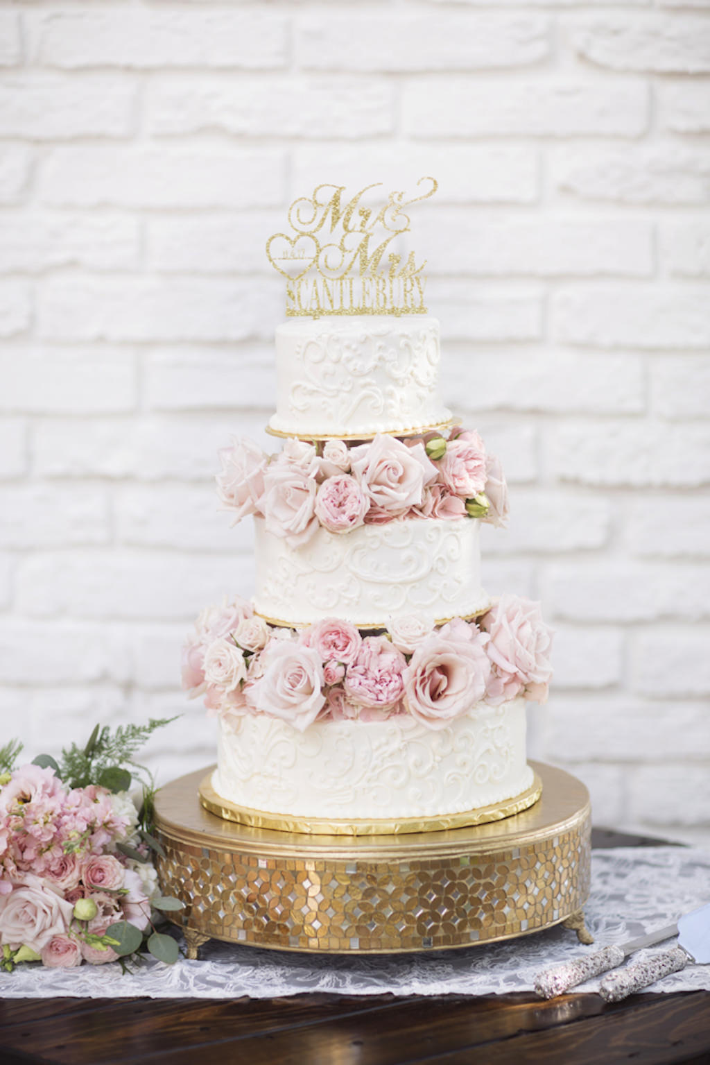 Three Tier Round White Wedding Cake with Blush Pink Roses, On Gold Cake Stand with Custom Gold Glitter Caketopper