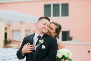 Outdoor Waterfront Hotel Rooftop Portraits, Bride with White Rose and Greenery Bouquet, Groom in Black Suit with Silver Vest and Boutonniere | Tampa Bay Wedding Photographer Kera Photography | Venue Hyatt Regency Clearwater Beach | Florist Apple Blossoms Floral Designs
