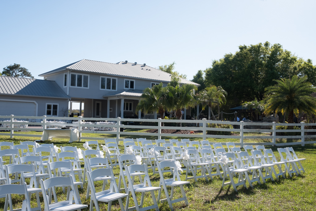 Rustic Outdoor Wedding Ceremony with White Folding Chairs with White Ribbon | Tampa Bay Farm Wedding Venue Southern Plantation Oasis