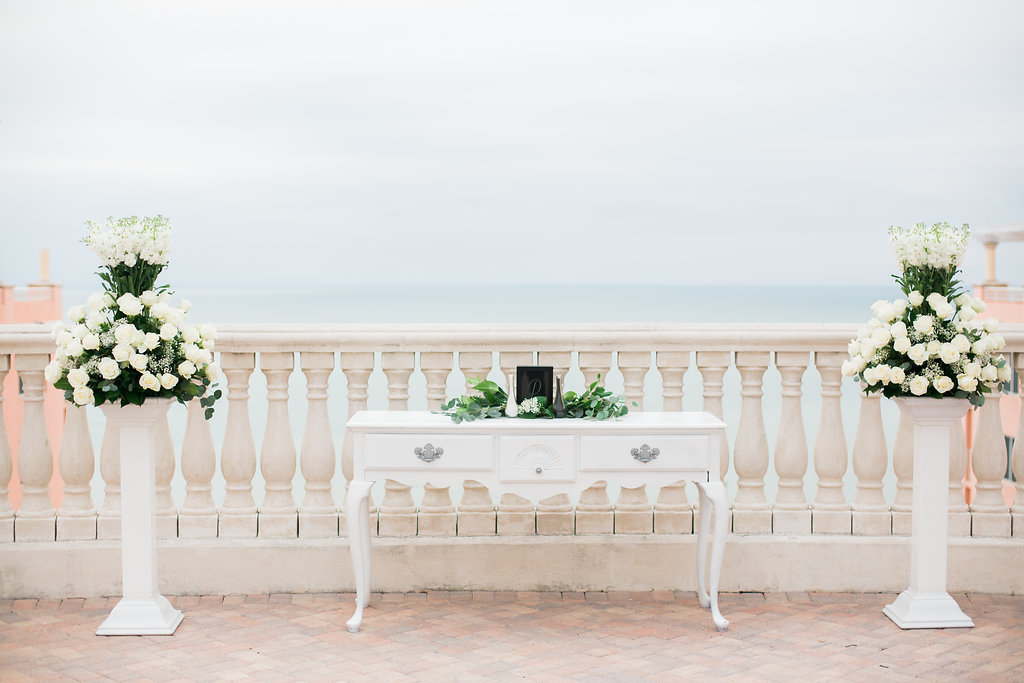 Waterfront Hotel Rooftop Elegant Wedding Ceremony with White Vintage Table, Tall White Rose Florals with Greenery on Pedestals | Venue Hyatt Regency Clearwater Beach | Tampa Bay Wedding Planner Special Moments Event Planning | Florist Apple Blossoms Floral Designs