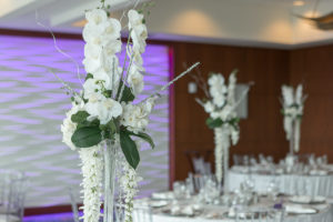 Elegant Hotel Ballroom Wedding Reception with Clear Chiavari Chairs, Round Tables, Silver Chargers, and Extra Tall Hanging White Floral with Greenery and Orchid Centerpiece | Tampa Bay Wedding Rental Company Kate Ryan Linen Rentals | Waterfront Venue Westin Tampa Bay