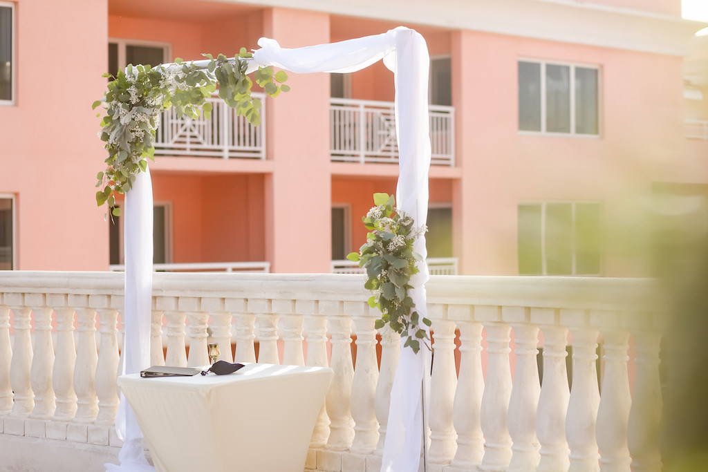Outdoor Hotel Rooftop Wedding Ceremony Arch with Greenery and White Floral and Draping | Tampa Bay Hotel Wedding Venue Hyatt Regency Clearwater Beach