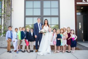 Outdoor Downtown Wedding Portrait with Kids, Bride in Sweetheart A Line Wedding Dress with Long Lace Edged Comb Veil and White and Pink Rose with Greenery Bouquet, Groom in Navy Blue Suit | Tampa Wedding Photographer Andi Diamond Photography