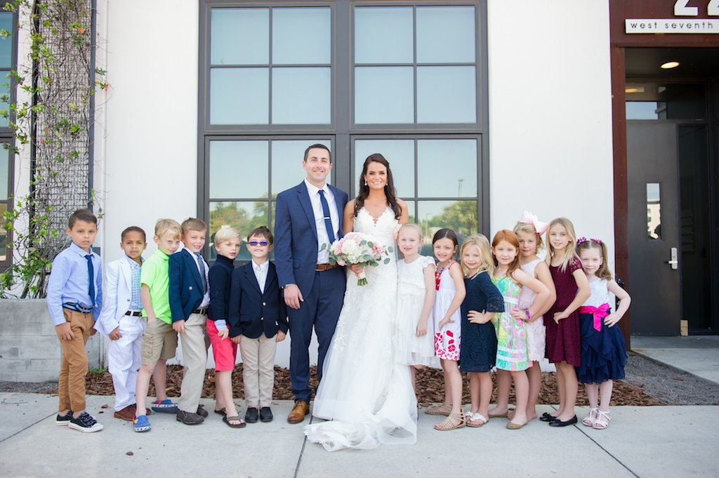 Outdoor Downtown Wedding Portrait with Kids, Bride in Sweetheart A Line Wedding Dress with Long Lace Edged Comb Veil and White and Pink Rose with Greenery Bouquet, Groom in Navy Blue Suit | Tampa Wedding Photographer Andi Diamond Photography