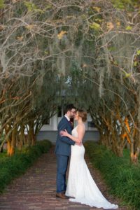 Creative Southern Romantic Wedding Portrait, Bride in Lace V Neck Paloma Blanca Dress, Groom in Gray Suit with Burgundy Red TIe | Tampa Bay Wedding Photographer Andi Diamond Photography | Venue Palmetto Riverside Bed and Breakfast