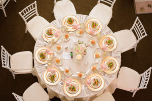 Elegant Romantic Wedding Reception Round Table with White Linen, Pink Napkins, Gold Chargers and Citrus Salads with Pink, White and Greenery Small Centerpiece and Chiavari Chairs | Tampa Wedding Caterer Olympia Catering