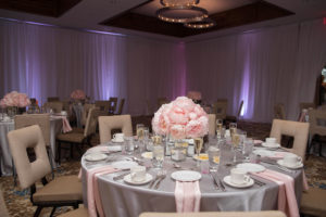 Modern Indoor Pink and Gray Wedding Reception Round Tables with with Satin Table Linens, Low Peony Centerpiece in Square Mirror Vase, with Modern Square Chairs and Purple Uplighting | Downtown Sarasota Wedding Venue The Francis