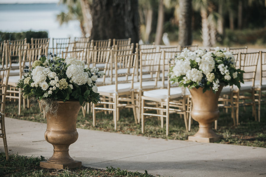 Outdoor Southern Waterfront Wedding Ceremony with Gold Chiavari Chairs, Large Classical Planters with White FLoral and Greenery | Bradenton Wedding Venue Powel Crosley Estate