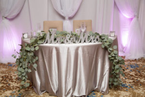 Modern Pink and Gray Wedding Reception Sweetheart Table with Satin Table LInen, White Draping, Oversized Mr and Mrs Silver Glitter Letters, and Greenery Garland Centerpiece | Downtown Sarasota Wedding Venue The Francis