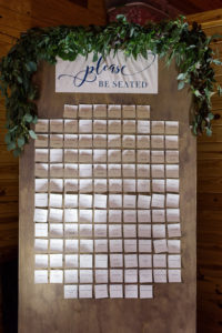 Rustic Wedding Reception Escort Cards on Vertical Board with Greenery Garland and Stylish Navy BLue on White Printed Sign | Tampa Bay Wedding Planner NK Productions