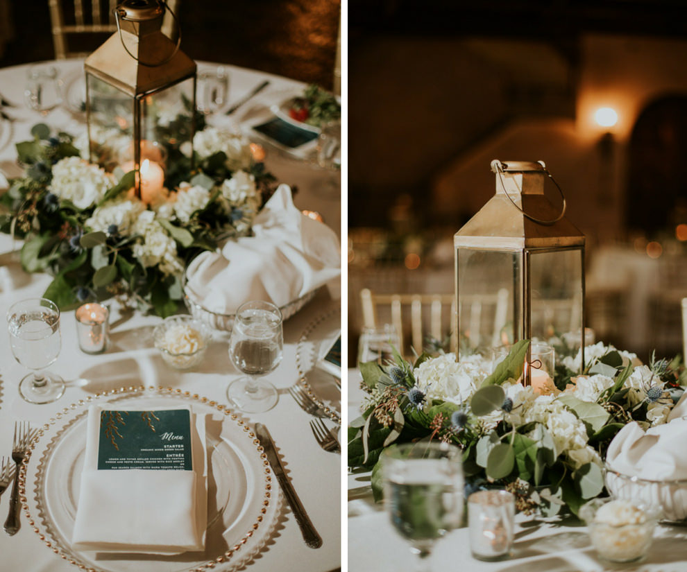 Indoor Wedding Reception with Low White and Greenery Centerpiece with Vintage Hurricane Lantern, Gold Beaded Clear Glass Chargers, Navy BLue, White and Gold Printed Menus, Gold Chiavari CHairs and White Linens | Bradenton Historic Wedding Venue Powel Crosley Estate