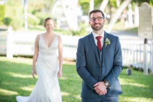 Outdoor First Look Portrait, Bride in Illusion Lace V Neck Paloma Blanca Dress, Groom in Gray Suit with Succulent Greenery Boutonniere and Red TIe | Sarasota Wedding Photographer Andi Diamond Photography