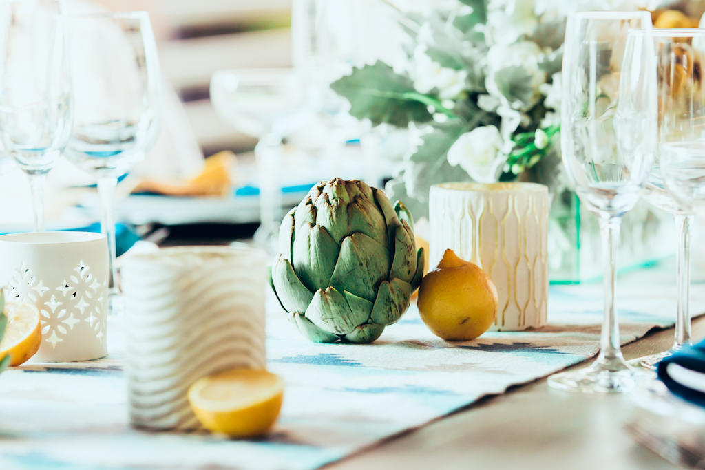 Summer Inspired Modern Wedding Reception Table Decor with White Porcelain Votive Candleholders, Woven Canvas Table Runner, Turquoise Napkins, Cut Yellow Lemon and Artichoke Accents | Tampa Bay Wedding Planner Jennifer Matteo Event Planning