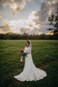 Outdoor Sunset Bride Wedding Portrait, Bride in Lace David's Bridal Wedding Dress, and Red Peonies, White Roses and Greenery Bouquet with Red and White Ribbon, and Lace Veil | Tampa Bay Wedding Photographer Rad Red Creative | Lithia Rustic Wedding Venue Southern Grace