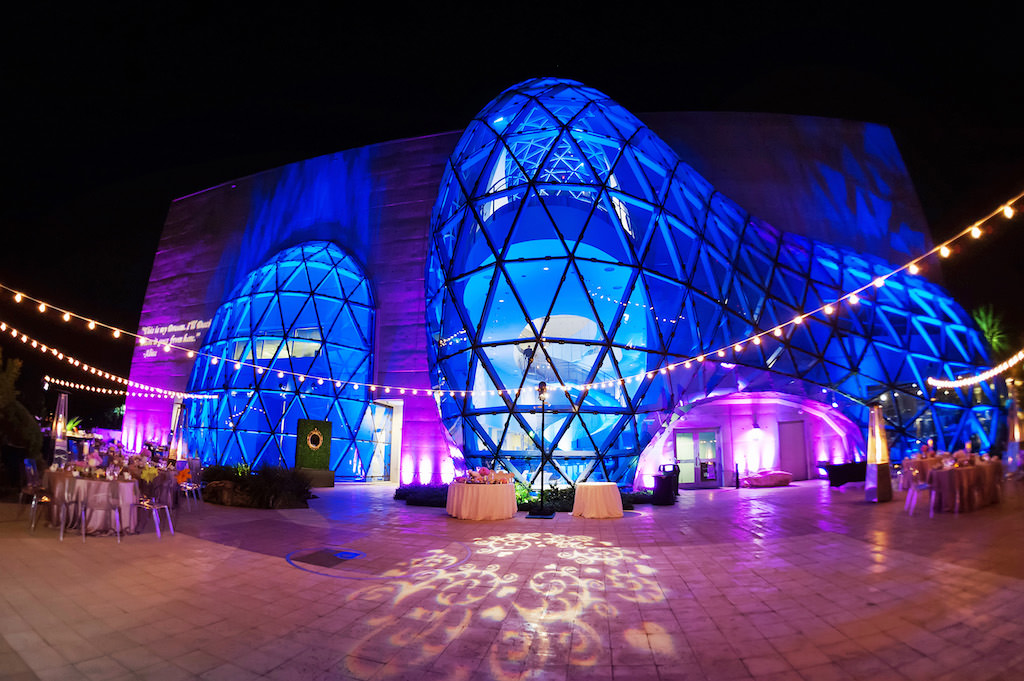 Salvador Dali Museum Outside Reception Venue with Triangular Windows, Blue and Purple Uplighting, Reception Tables and Hanging Bistro Lights