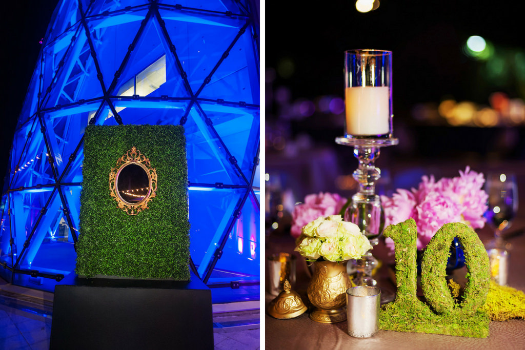 Blue Uplighted Triangular Windows Salvador Dali Museum Reception Venue with Greenery and Oval Vintage Mirror Sculpture and Reception Dinner Centerpiece with Tall Glass Candle Holder Greenery Table Number 10 and Small Gold Vintage Vase with Green and Pink Flowers