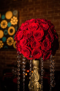 Great Gatsby Inspired Indoor Wedding Reception Decor Centerpiece at St. Pete Venue, Round Red Roses Bouquet on Gold Vintage Pedestals with Hanging Crystals | Downtown St. Pete Wedding Venue NOVA 535