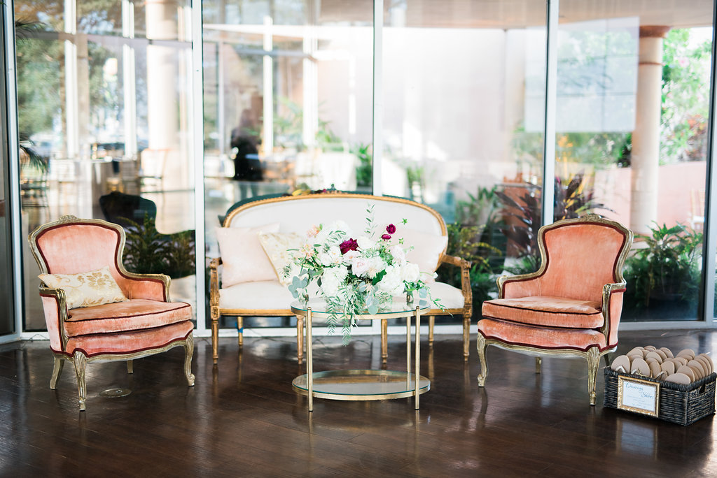 Outdoor Waterfront Wedding Vintage Glam Inspired Reception Lounge with Antique Plush Ivory and Gold Loveseat and Coral Velvet Chairs and Gold Cocktail Table with White and Red Roses and Greenery Organic Bouquet | Naples Wedding Photographer Kera Photography | St. Pete Wedding Venue Museum of Fine Art St. Petersburg