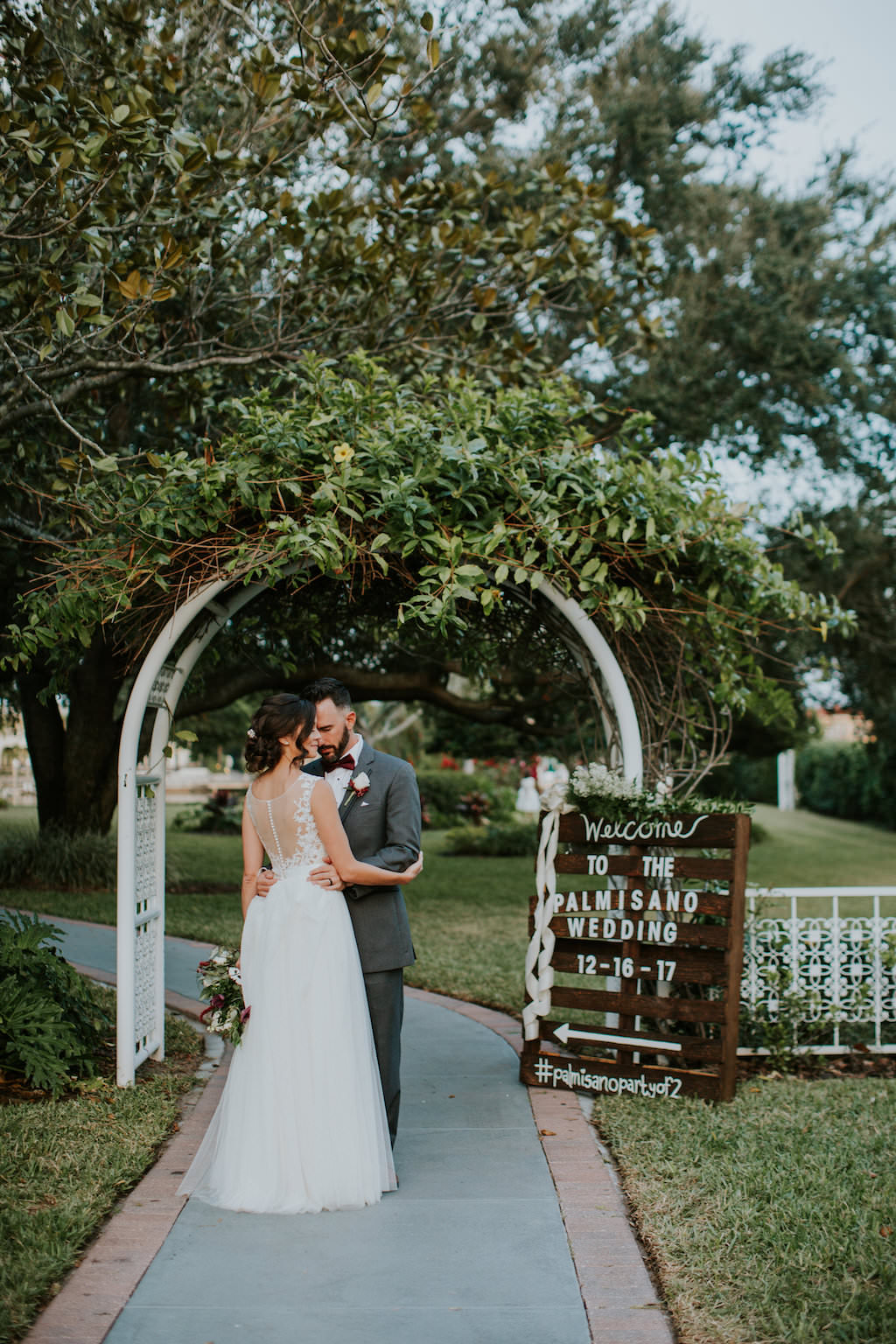 Outdoor Bride and Groom Wedding Portrait. White Arch and Rustic Wooden Crate Sign | Tampa Bay Wedding Venue Davis Islands Garden Club