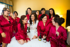 Bride and Bridesmaids Getting Ready Wedding Portrait in Matching Red Robes Bride Wearing White | Tampa Bay Hair and Makeup Artist Femme Akoi