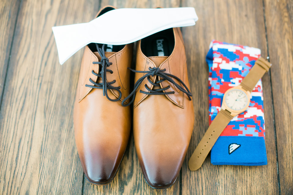 Groom Accessories including Brown Leather Wing Tip Shoes, White Bowtie, Brown Leather Watch, and Red and Blue Socks| Naples Wedding Photographer Kera Photography