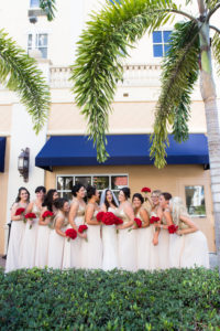 Outdoor Bridal Party Portrait, Bridesmaids in Matching Gold and Ivory Floor Length Dresses with Red Roses Bouquets and Bride Wearing Sweetheart White Lace Wedding Dress | St. Pete Wedding Coordinator NOVA 535