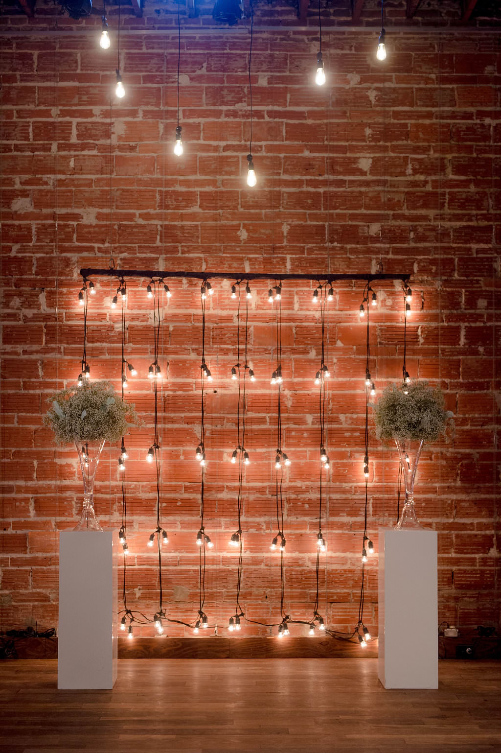 Exposed Brick and Industrial String Lights, White Pedestals with Glass Cylinders and Baby's Breathe | Modern Industrial Wedding Reception Decor Inspiration | Downtown St. Petersburg Wedding Venue NOVA 535 | St. Pete Photographer Marc Edwards Photography