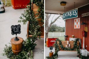 Outdoor Rustic Wedding Decor Wooden Bench Decorated with Greenery Garland, Silver Candle Pedestals with White Pillar Candles, Wooden Barrel with Chalkboard Sign | Tampa Bay Wedding Photographer Rad Red Creative | Lithia Wedding Venue Southern Grace