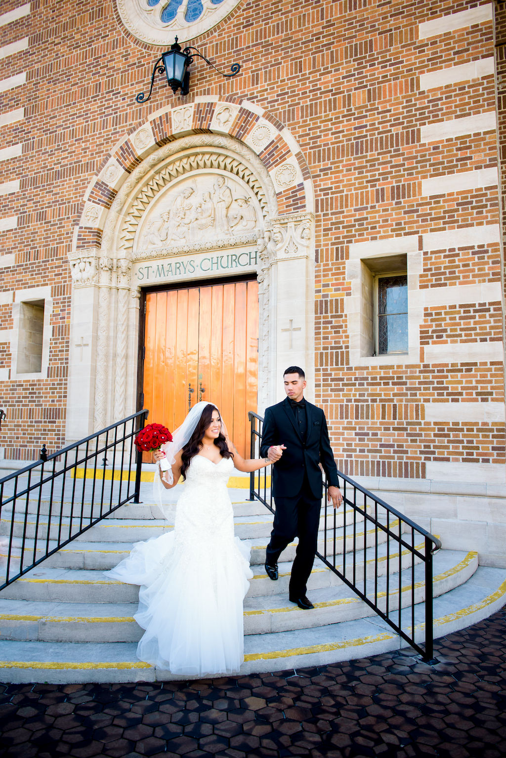 St. Petersburg Wedding Ceremony Venue St Mary Our Lady of Grace Catholic Church, Bride Wearing Sweetheart White and Tulle Wedding Dress with Tulle Veil Holding Red Rose Bouquet, Groom Wearing Black on Black Suit