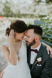 Bride and Groom First Look Portrait, Groom in Grey Tuxedo and Burgundy Bowtie with White Rose and Red Flower Boutonniere, Bride in Boho Chic V-Neck Lace Illusion White Wtoo Wedding Dress | Tampa Bay Wedding Venue Davis Islands Garden Club