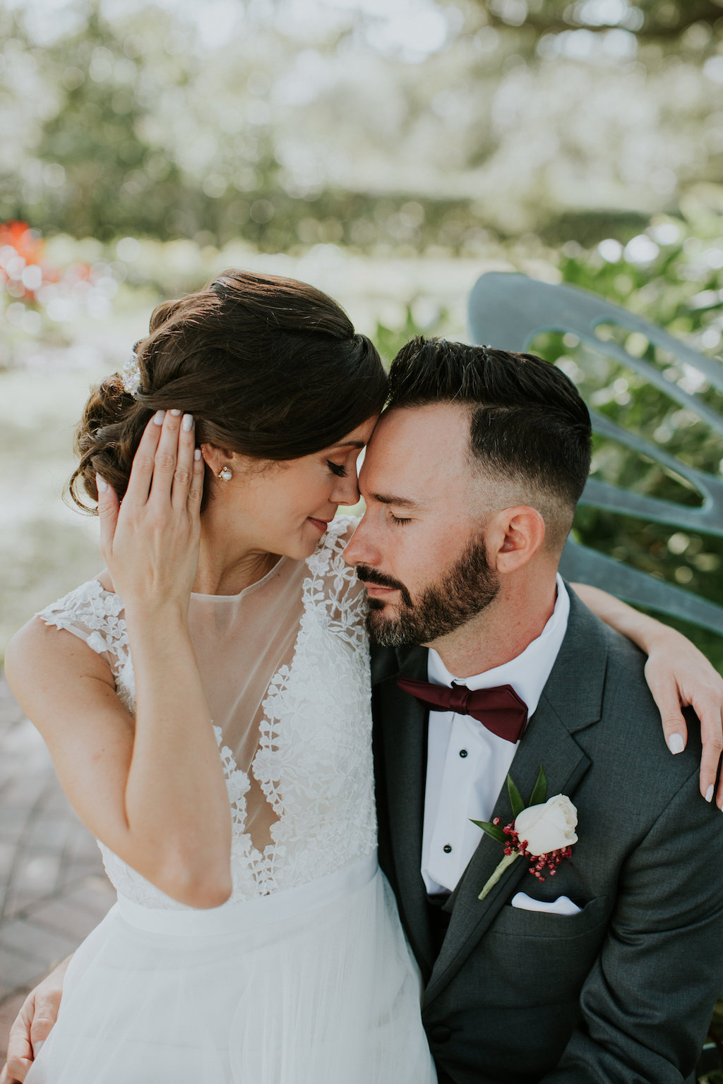 Bride and Groom First Look Portrait, Groom in Grey Tuxedo and Burgundy Bowtie with White Rose and Red Flower Boutonniere, Bride in Boho Chic V-Neck Lace Illusion White Wtoo Wedding Dress | Tampa Bay Wedding Venue Davis Islands Garden Club