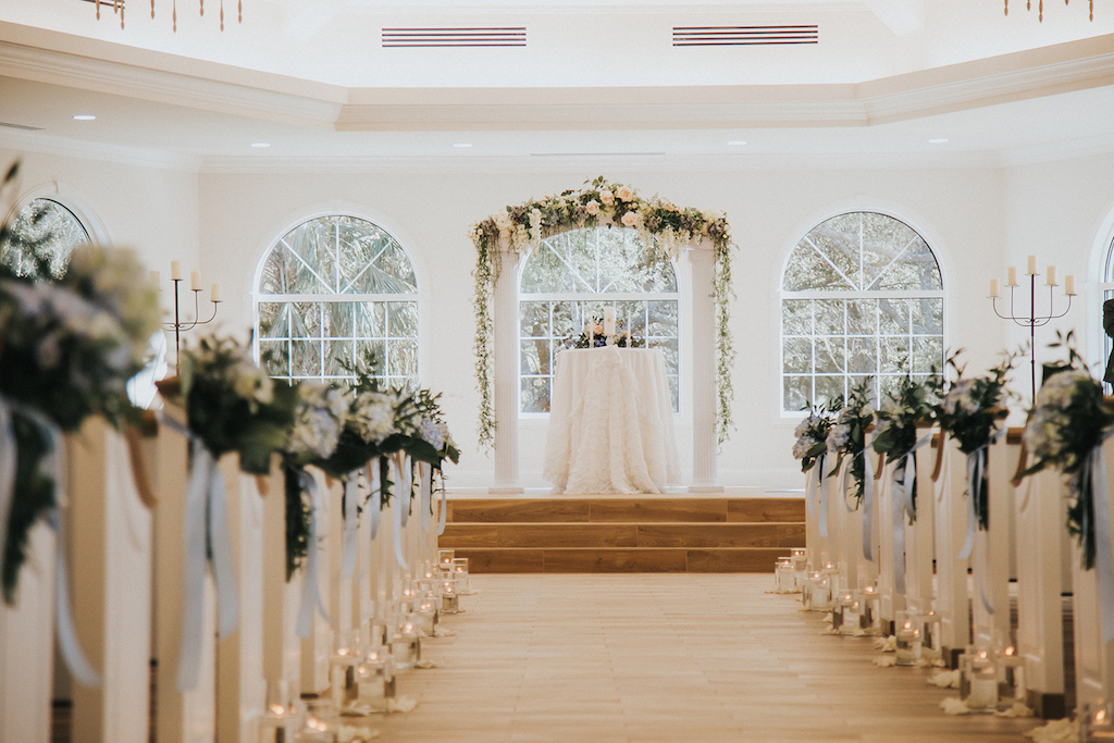 White Ceremony Decor with Candle Aisle Decor and Greenery Altar Arch | Safety Harbor Wedding Ceremony Venue Harborside Chapel