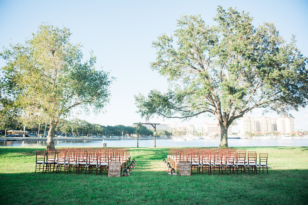 Waterfront Outdoor Vintage Wedding Ceremony with Wooden Signs, Wooden Arch and Brown Chiavari Chairs | Outdoor Downtown St. Pete Garden Wedding Ceremony North Straub Park