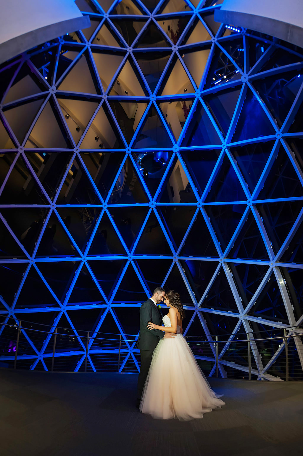 Bride and Groom at Salvador Dali Museum with Triangular Window Backdrop and Blue Uplighting