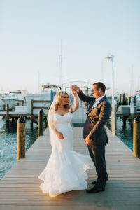 Romantic, Waterfront Bride and Groom Wedding Portrait, Bride in Mikaella Off the Shoulder, Sweetheart Wedding Dress and Tulle Veil, Groom in Grey Suit and White Cala Lillie Boutonniere | St. Pete Beach Wedding Venue Isla Del Sol Yacht and Country Club