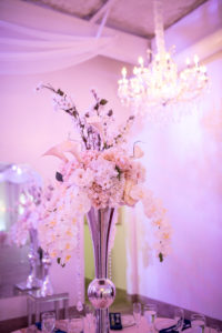 Elegant, Indoor Wedding Reception Decor Tall Silver Vase with White Orchids, Cala Lillies and Hanging Crystals Centerpiece and Pink Uplighting