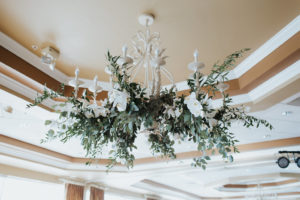 Ballroom Wedding Ceremony Décor with Greenery and White Floral Draped Chandelier | St. Pete Wedding Venue Isla Del Sol Yacht and Country Club