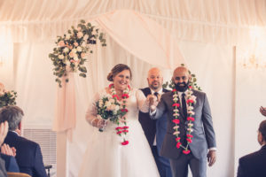 Bride and Groom Wedding Ceremony Portrait Wearing Pink Floral Leis, White and Blush Drapery Background with Pink, White and Greenery Floral Bouquet | Tampa Bay Wedding Photographer Luxe Light Photography | Tampa Bay Wedding Venue Safety Harbor Resort and Spa