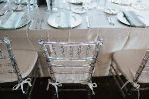 Ballroom Wedding Reception Decor, Clear Acrylic Chairs with White Satin Cushions, Satin White Tablecloth, Silver Plate Chargers and Green Linens | St. Petersburg Wedding Rentals Gabro Event Rentals and Over the Top Linen Rentals