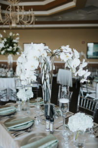 Elegant, Ballroom Wedding Reception Decor, Tall White Orchid Centerpiece in Glass Cylinder on White Satin Tablecloth, with Silver Plate Chargers and Mint Green Linens | St. Petersburg Wedding Venue Isla Del Sol Yacht and Country Club | St. Petersburg Wedding Rentals Over the Top Rentals and Gabro Event Rentals