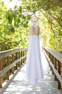 A-Line Scoop Neck Nude Rhinestone Bodice and White Chiffon Floor Length Wedding Dress on Hanger Outdoors | Tampa Bay Wedding Photographer Lifelong Photography Studios