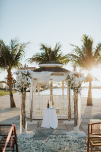 Outdoor Beach Wedding Ceremony at Gazebo with Birchwood Arch, White Draping and White Florals | Waterfront Venue Isla Del Sol Yacht and Country Club