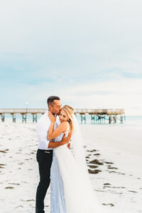 Coastal, St. Pete Beach Waterfront Bride and Groom Wedding Portrait, Bride in Sleeveless Illusion Neckline Floral Overlay and Light Blue Wedding Dress with Tulle Skirt and Veil