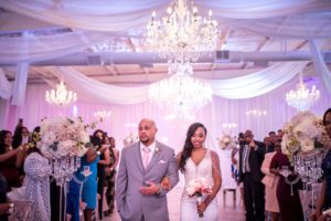 Bride Walking Down the Aisle Ceremony Portrait with Dad in V-neck Beaded Rhinestone Bodice Wedding Dress and Veil, Blush Pink Rose Bouquet, White Draping and Crystal Chandeliers | Tampa Bay Wedding Venue The Crystal Ballroom